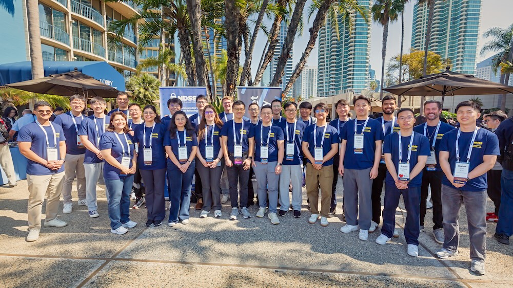 a group of young people posing for a photo outdoors